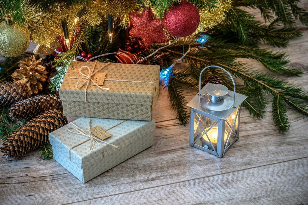 light brown flooring, silver lantern with candle, simple decorating with branches, boxes with gifts and lights with ornaments