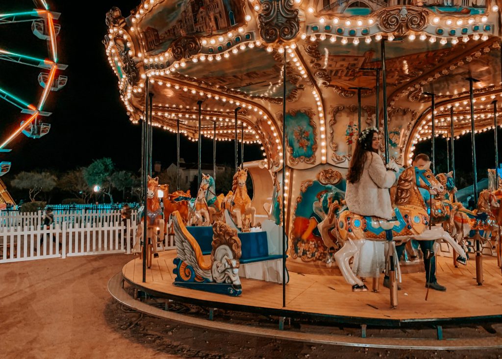 carousel with kids riding on it at an amusement park at night