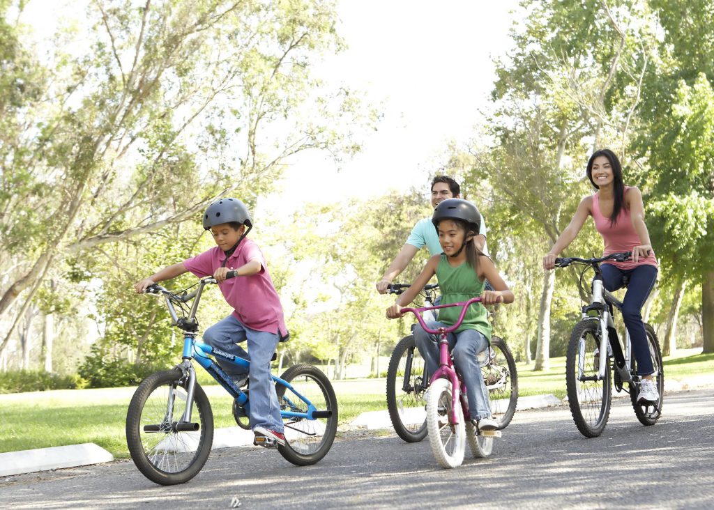 Family riding bikes at a local park